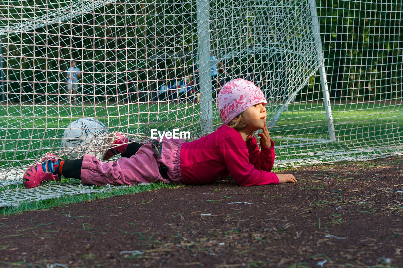 Girl lying on net over field