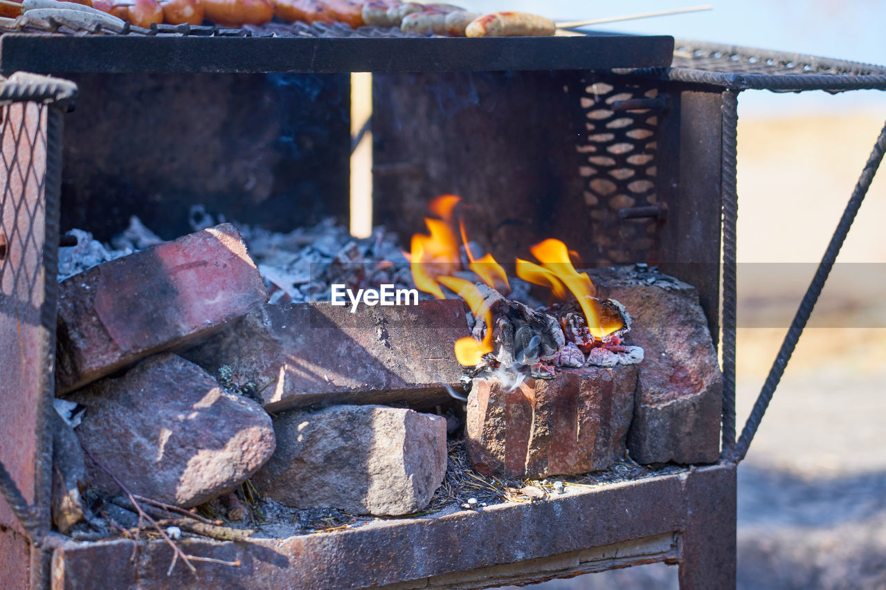 Fire in a rusty vintage grill outdoor with blurred background.