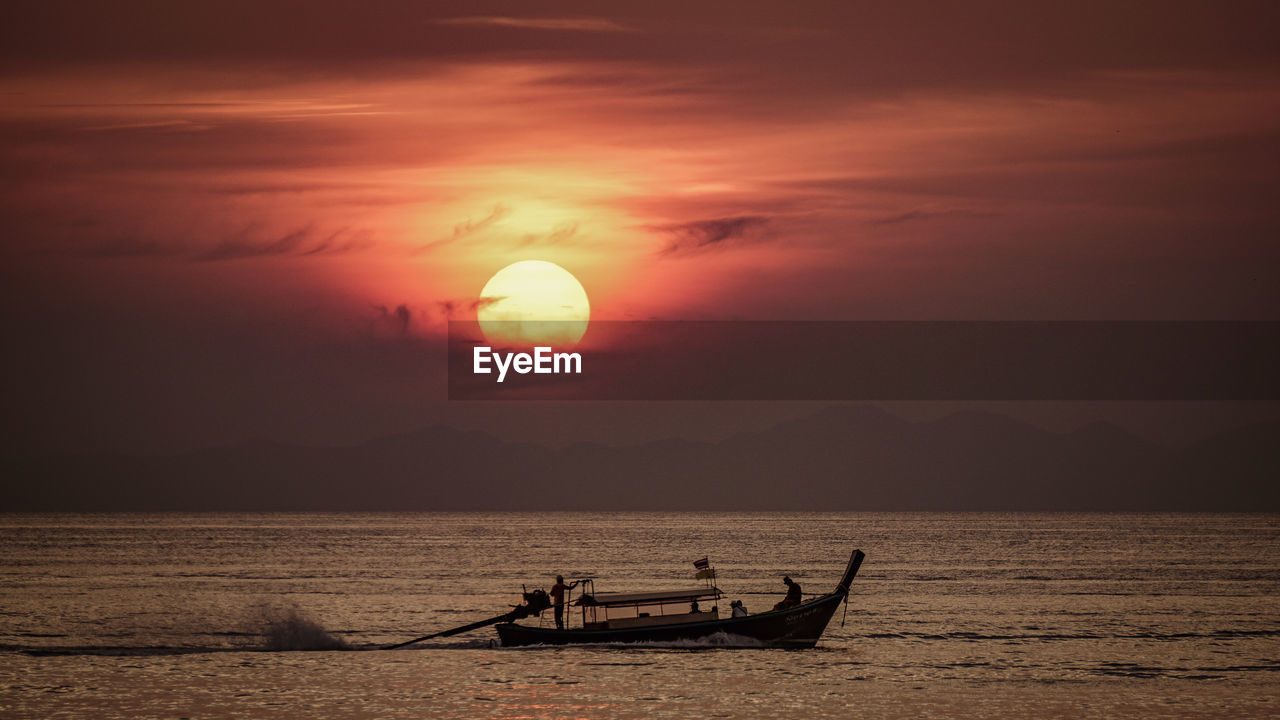 SILHOUETTE BOAT IN SEA AGAINST ORANGE SKY