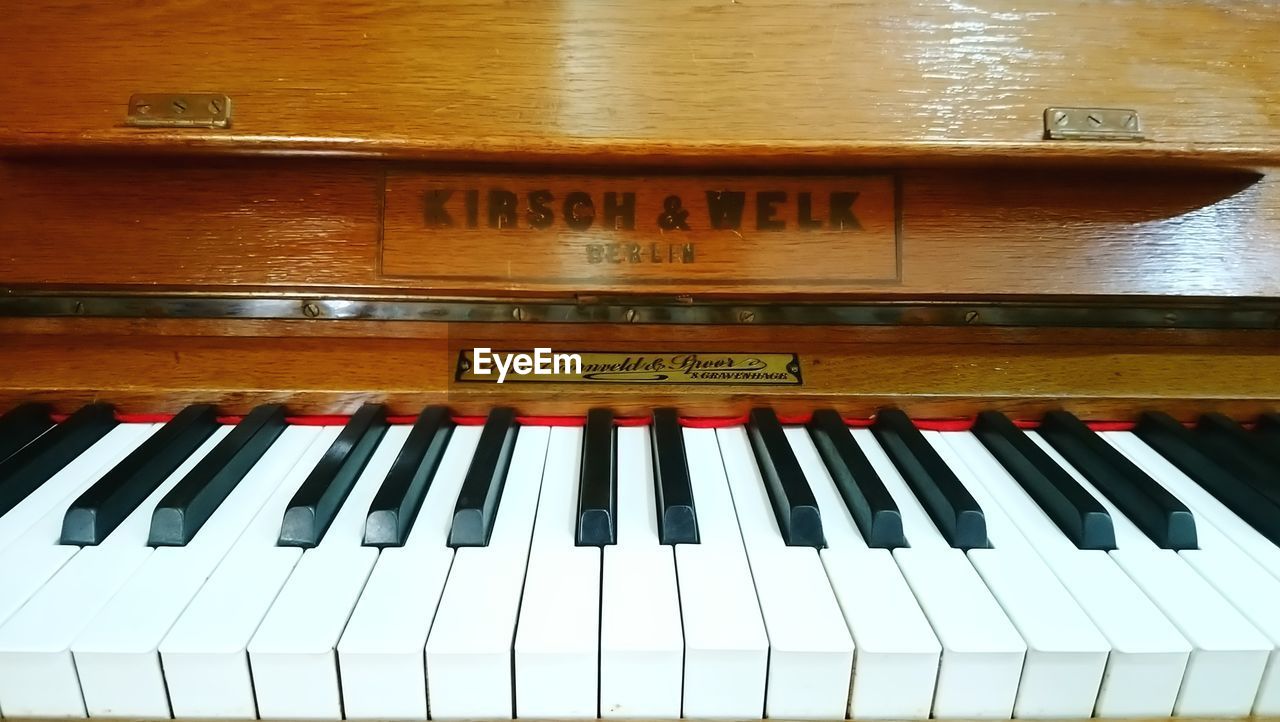 HIGH ANGLE VIEW OF PIANO KEYS ON WOODEN FLOOR