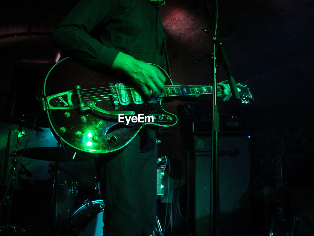 Midsection of man playing guitar