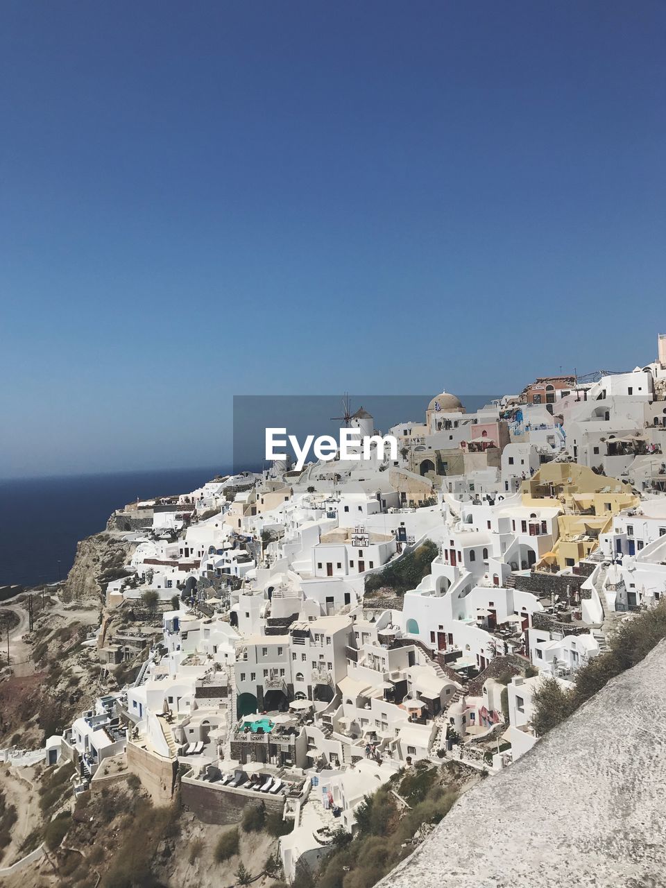 Aerial view of town by sea against clear sky