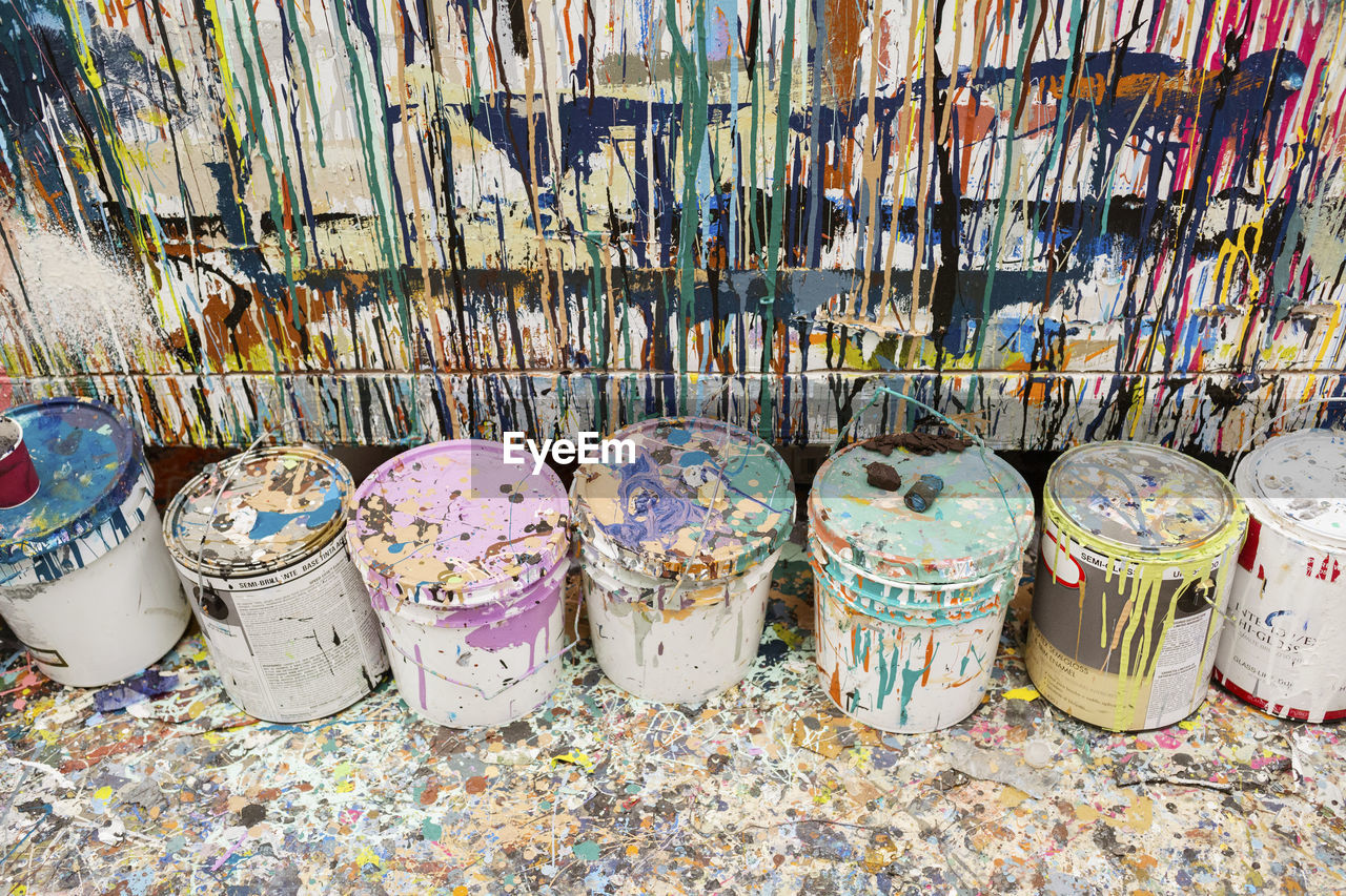 High angle view of dirty paint cans at art studio