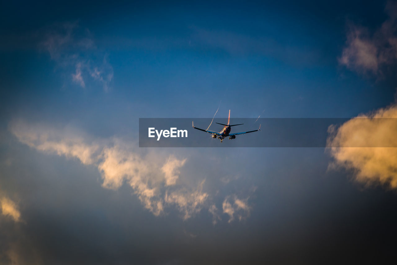 flying, air vehicle, sky, transportation, mode of transportation, airplane, cloud, nature, mid-air, on the move, travel, motion, wing, low angle view, no people, vehicle, outdoors, aircraft, air travel, blue, journey, aviation