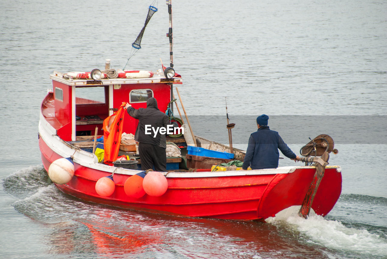 MEN SITTING IN BOAT