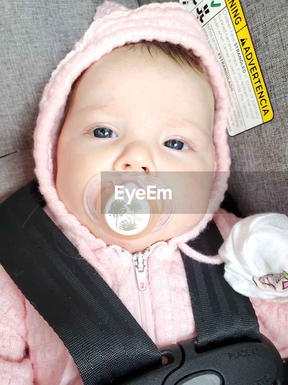 CLOSE-UP PORTRAIT OF CUTE BABY GIRL HOLDING CAMERA IN A HAND
