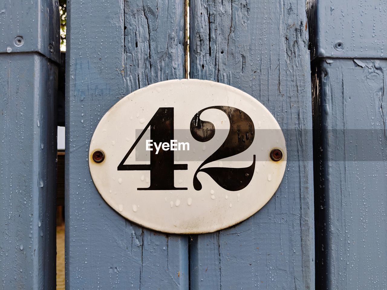 Close-up of sign on wooden fence