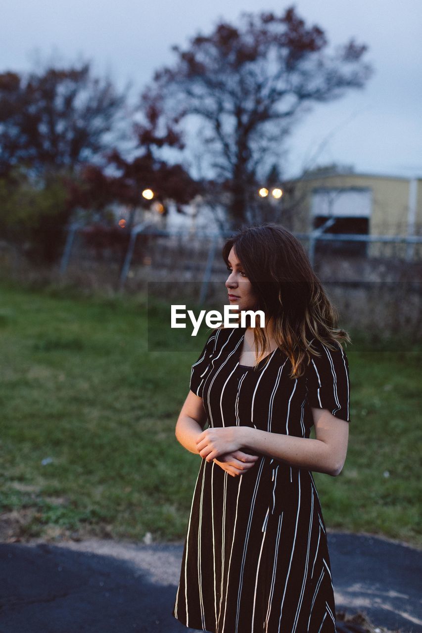 Fashionable teenage girl standing outdoors