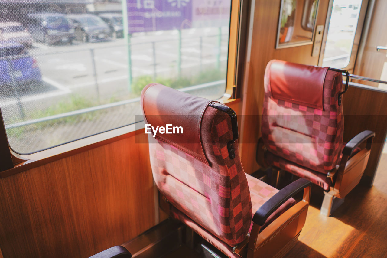 Empty chair by window in train