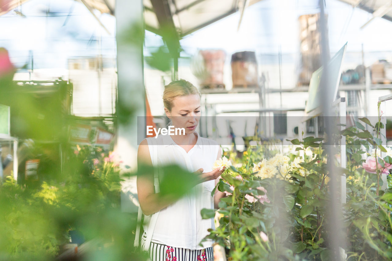 Beautiful woman standing at flower shop