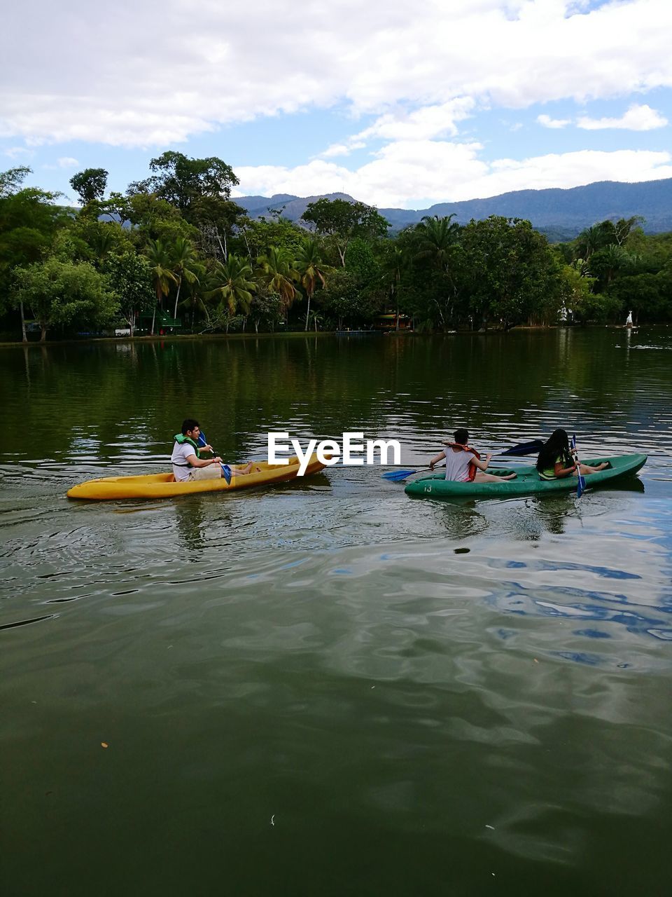 BOATS IN RIVER AGAINST CLOUDY SKY