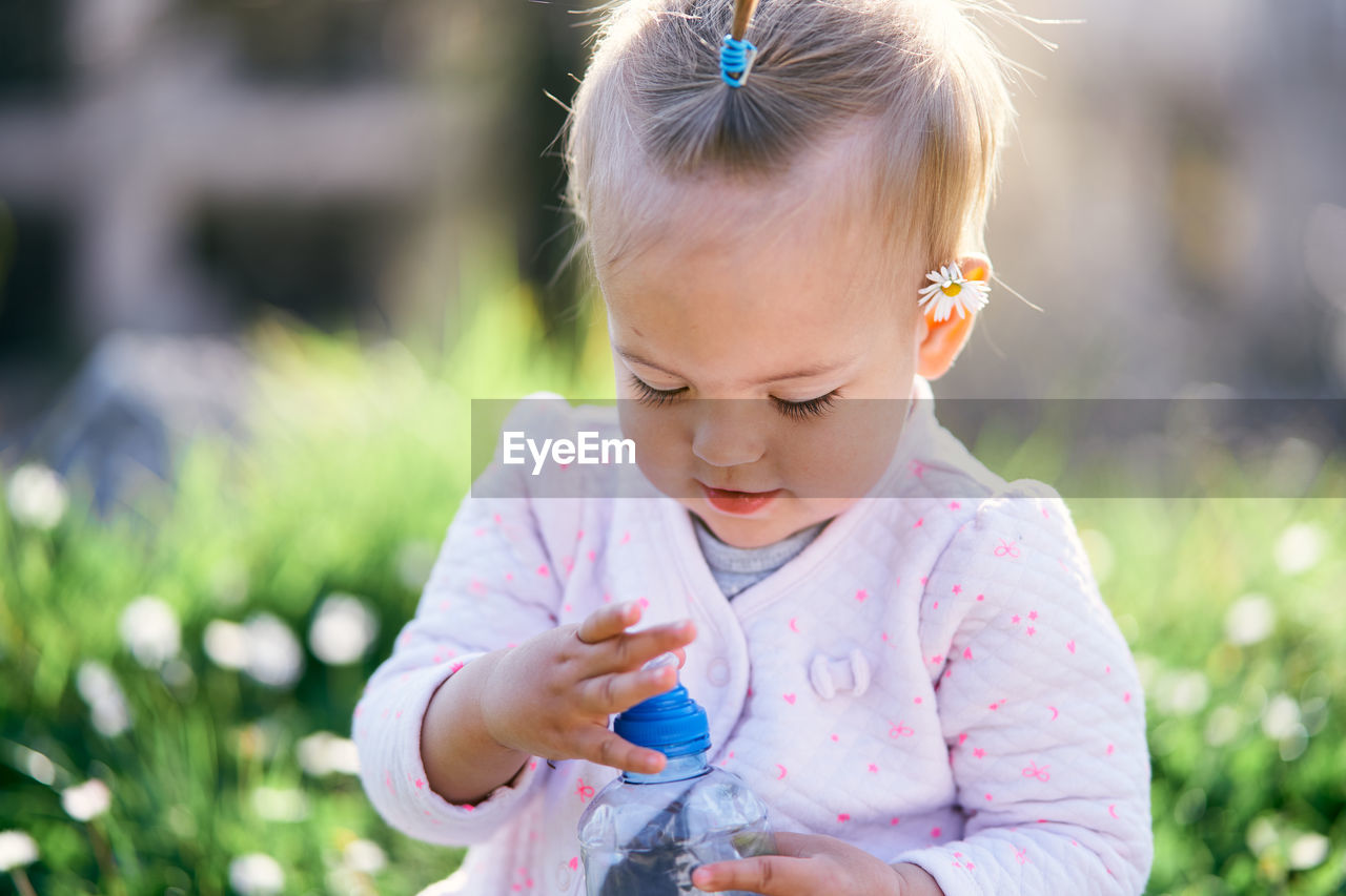 Close-up of cute girl holding plant