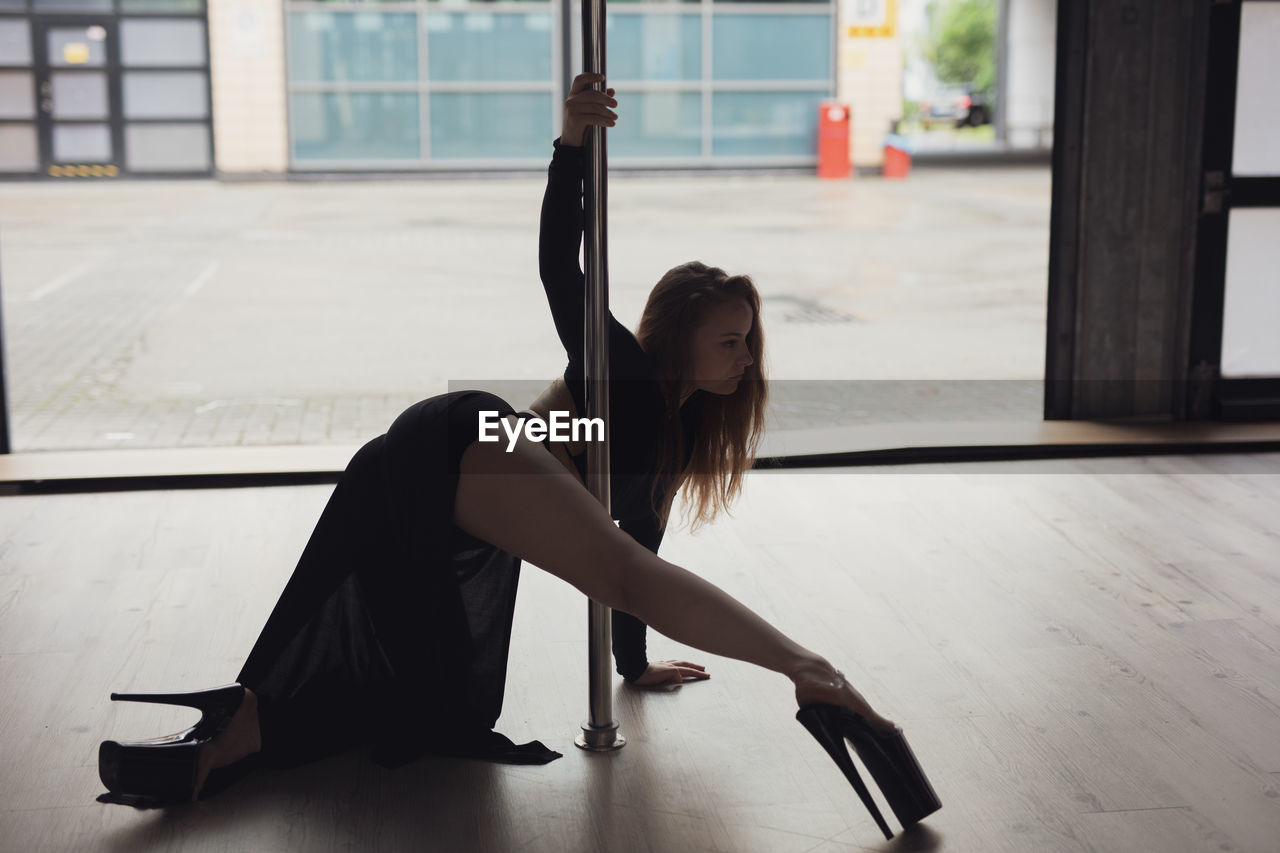 side view of woman exercising on floor