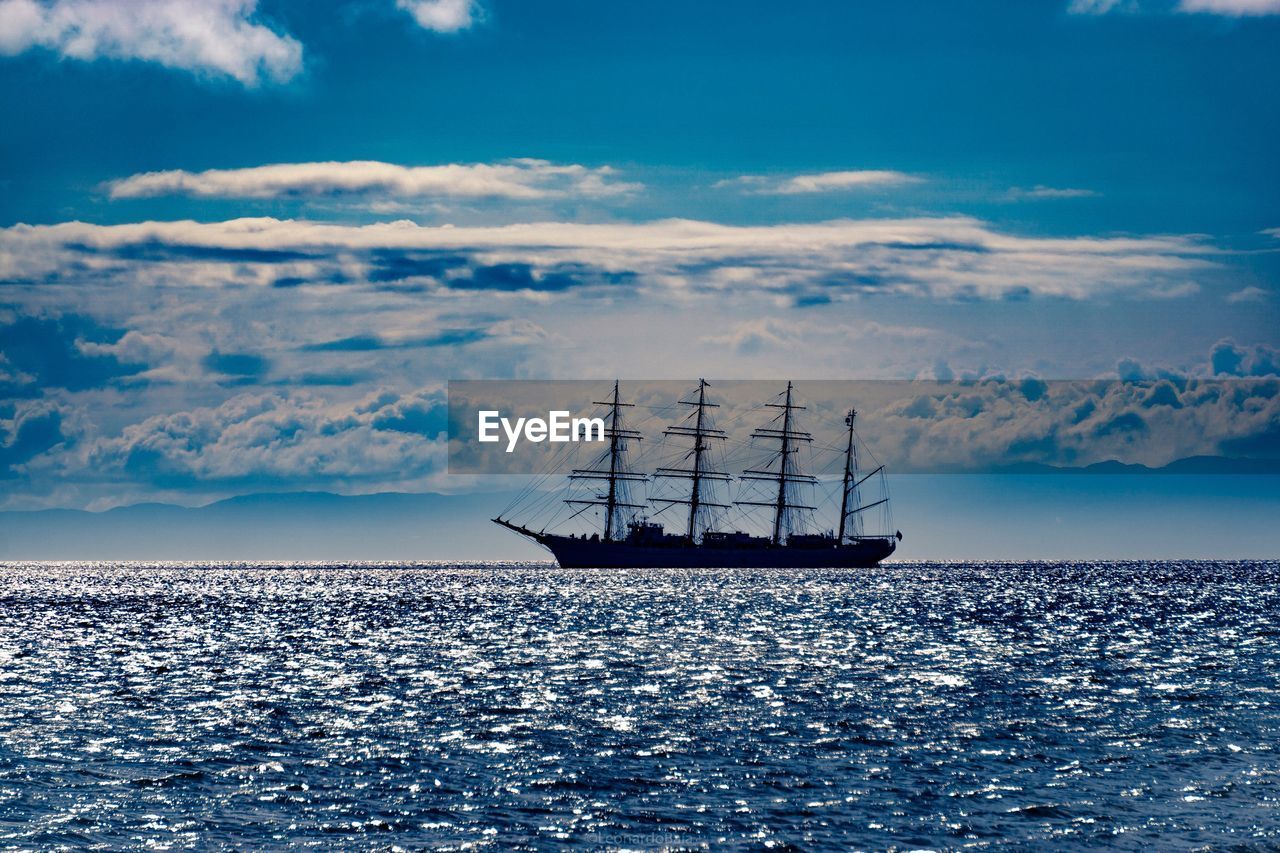 Sailboat sailing in sea against sky