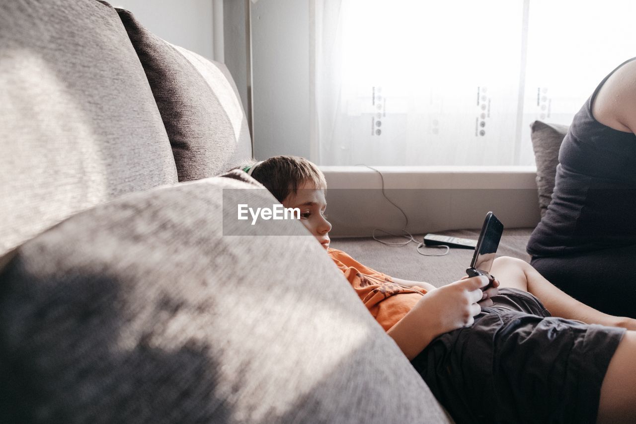 Boy using mobile phone at home