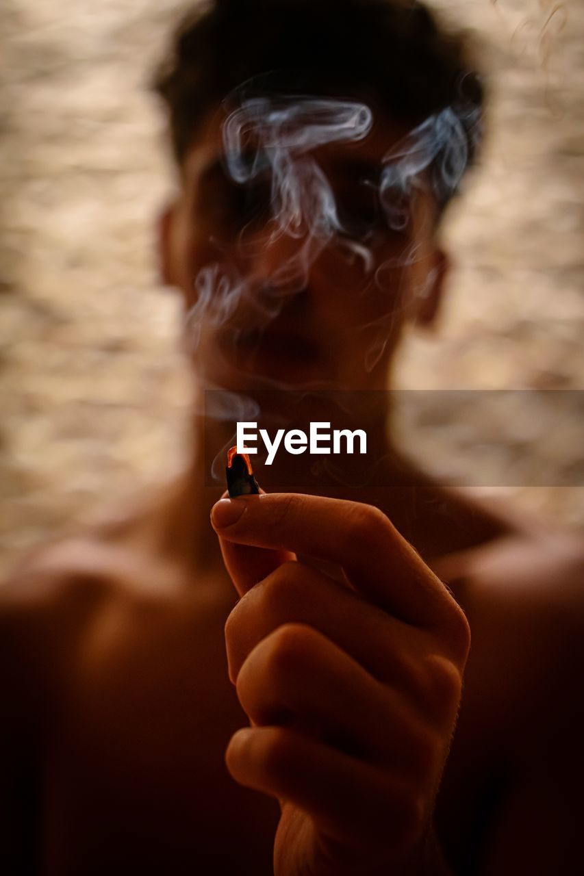 Cropped hand of man smoking cigarette
