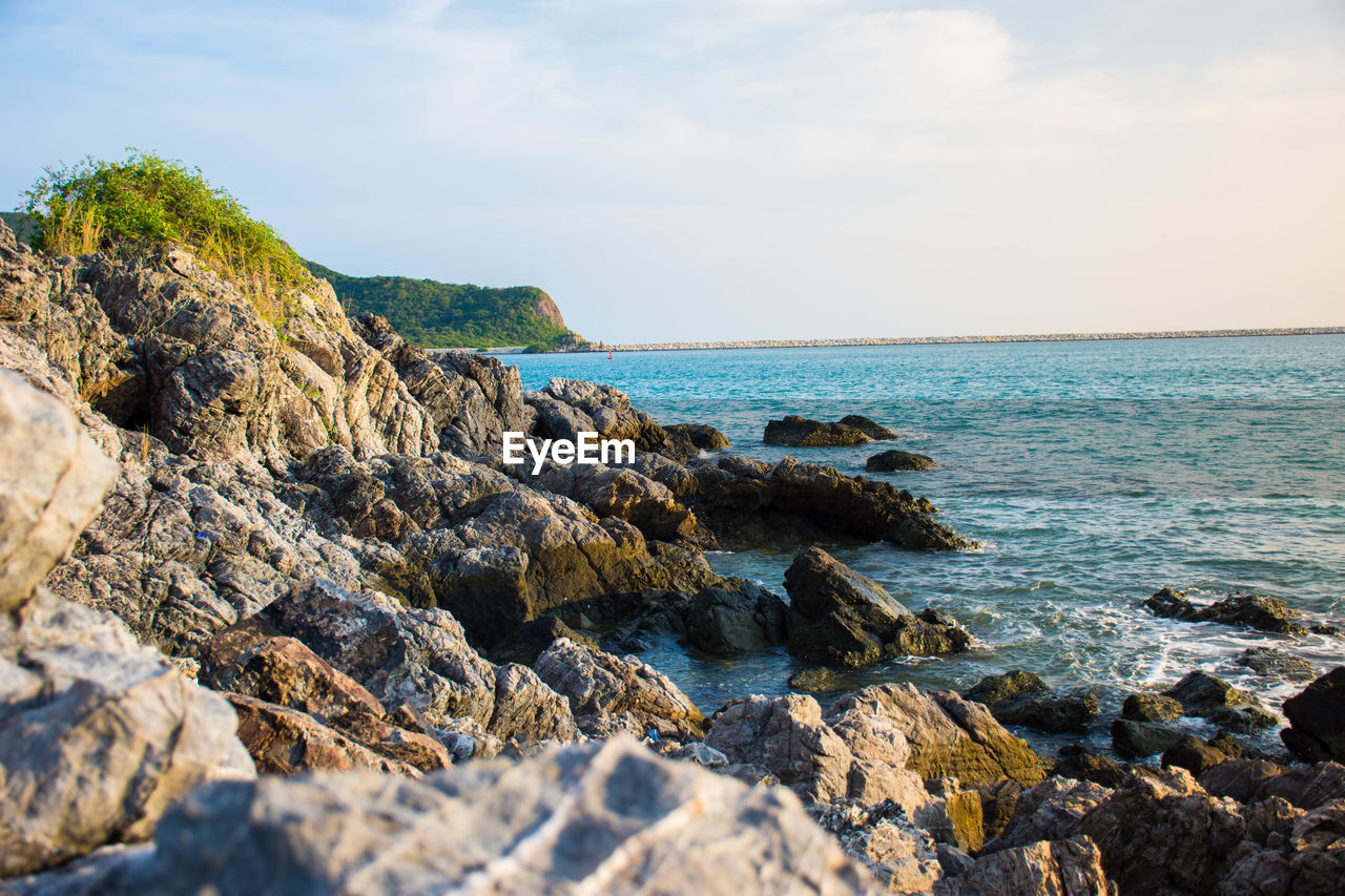 SCENIC VIEW OF ROCKS ON BEACH AGAINST SKY