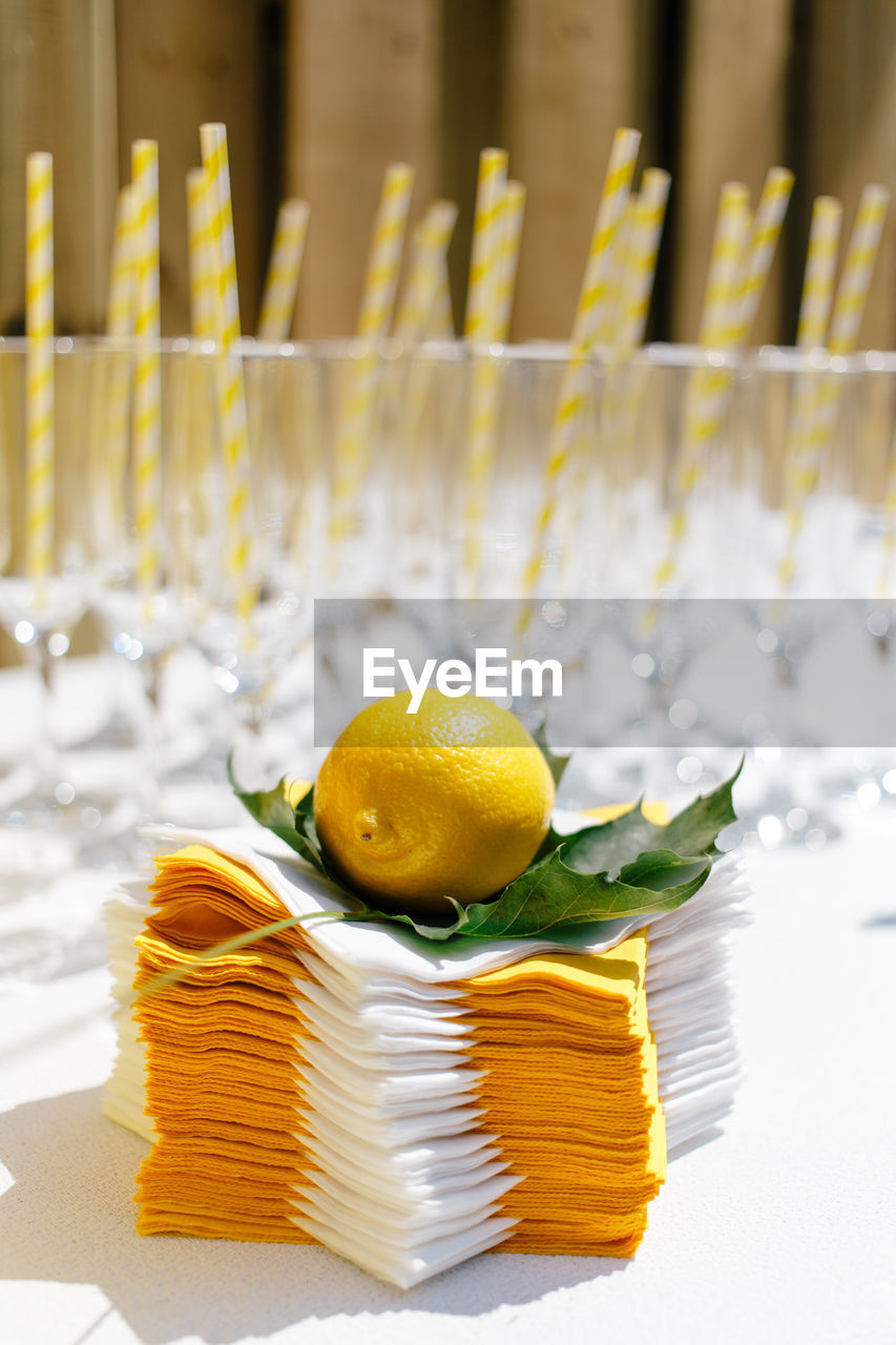 Close-up of lemon with leaf on napkins