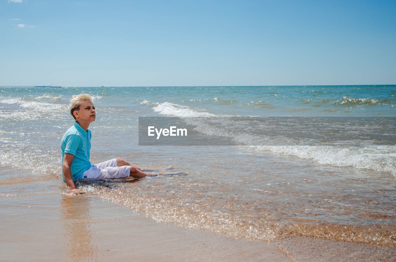 rear view of woman standing at beach