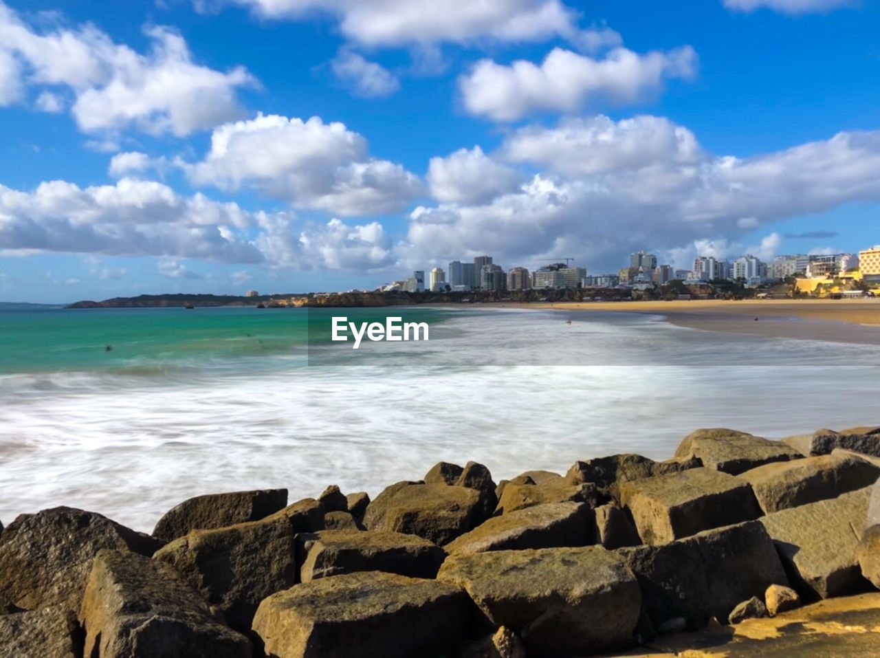 Long exposure of beachfront with border rocks