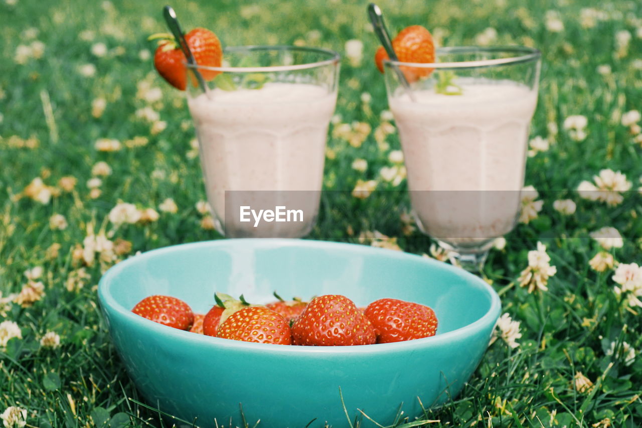 Close-up of strawberries in bowl with drinks