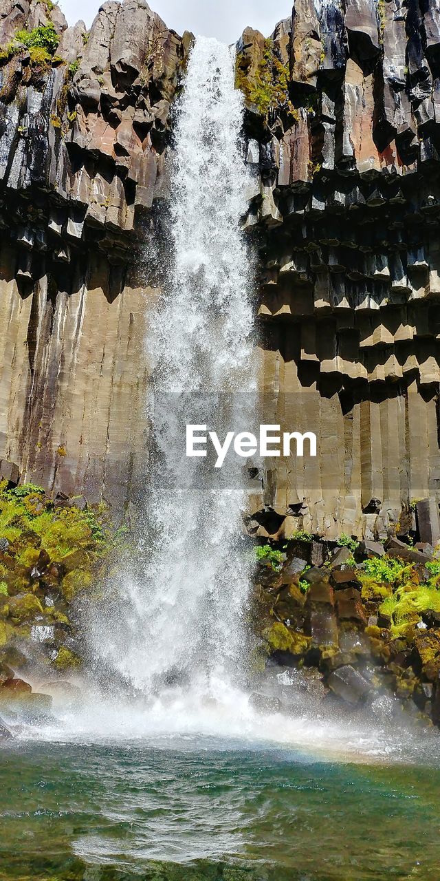 CLOSE-UP OF WATER SPLASHING ON ROCKS