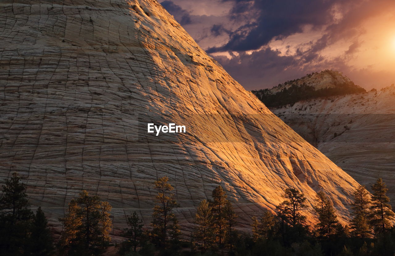 LOW ANGLE VIEW OF SUN SHINING THROUGH ROCKS