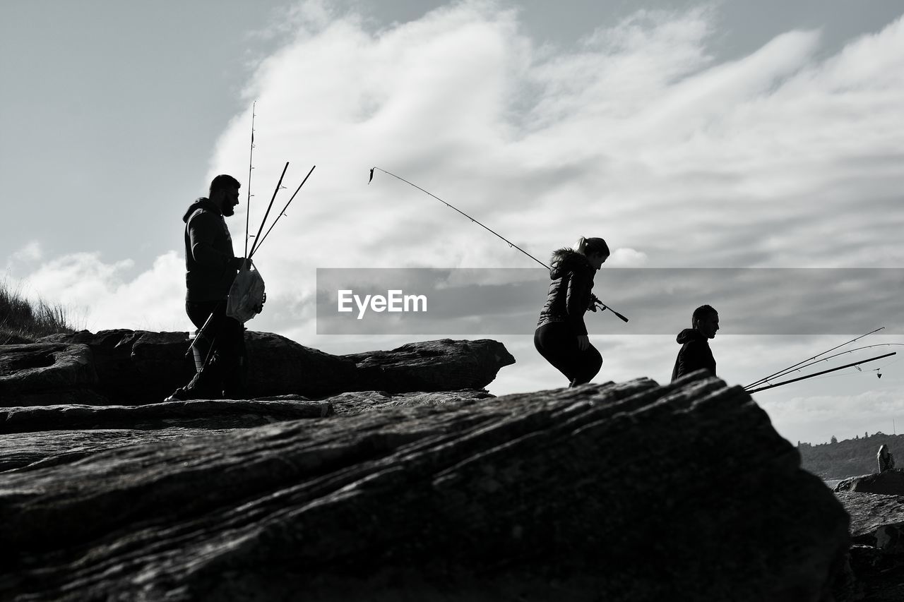 LOW ANGLE VIEW OF SILHOUETTE PEOPLE ON MOUNTAIN