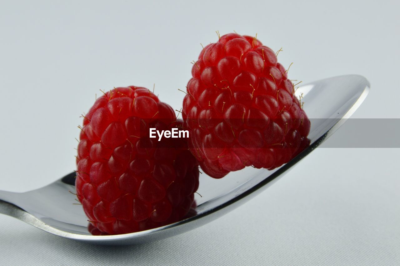 Close-up of raspberries on spoon on table