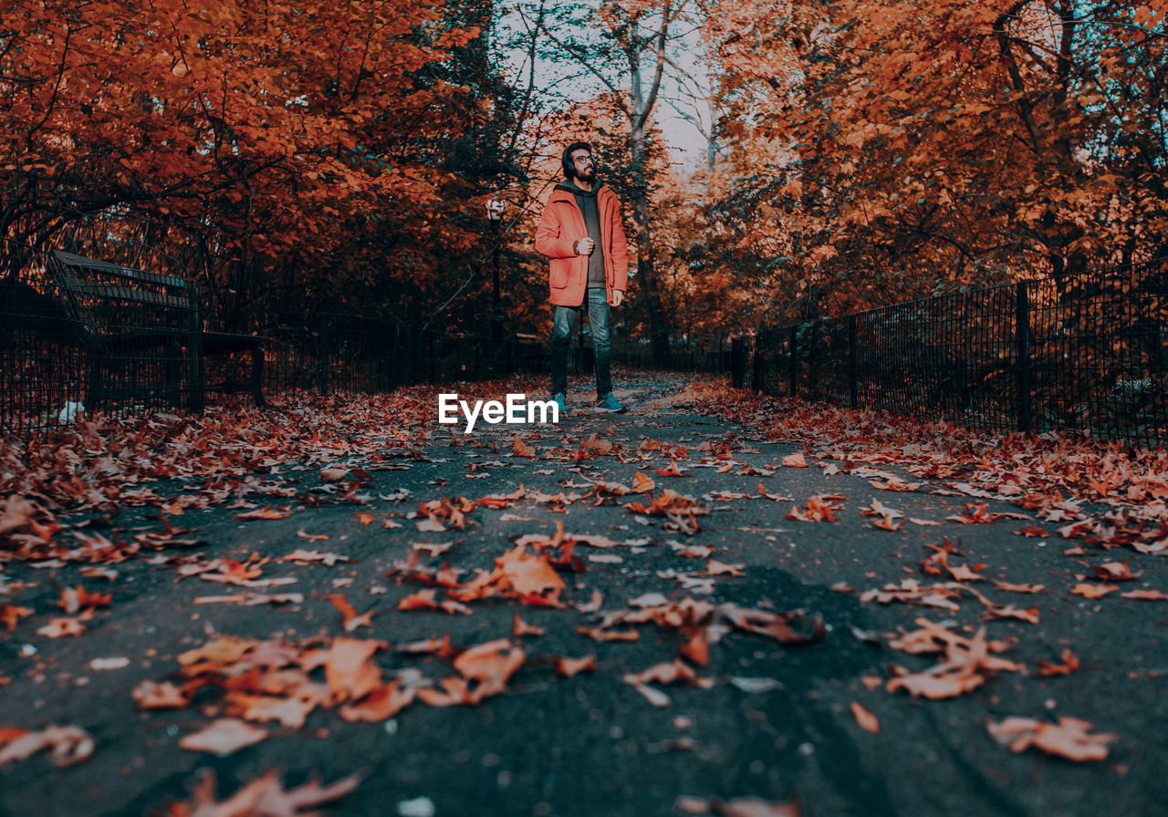 Full length of man standing on road during autumn