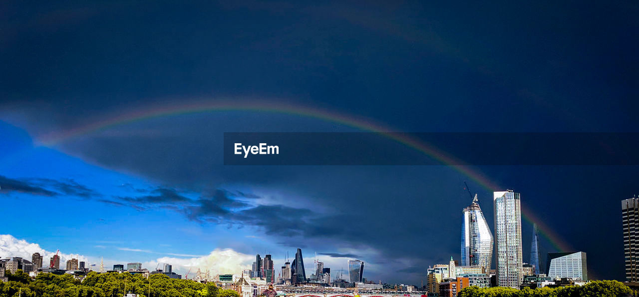 Rainbow over buildings in city