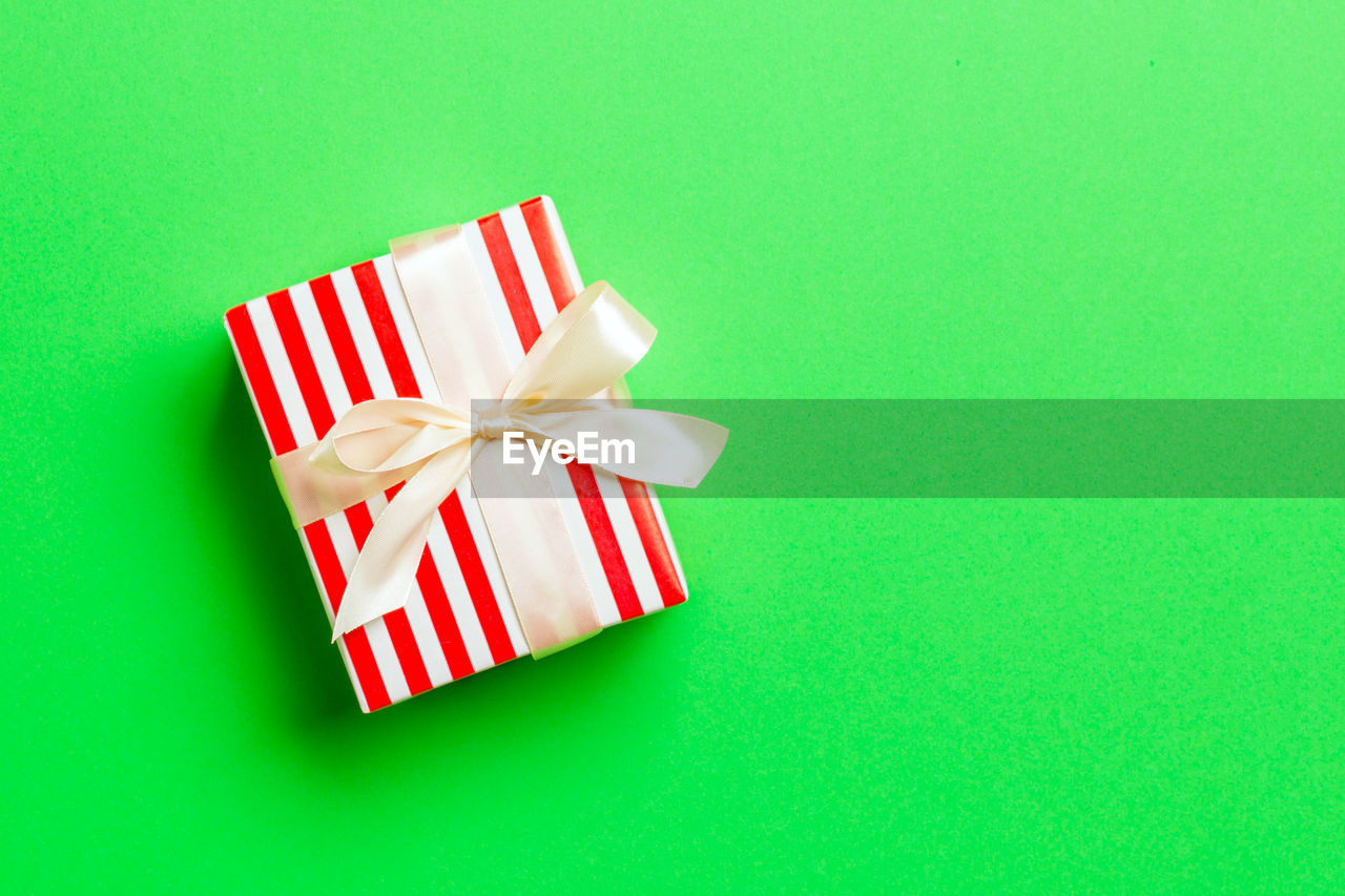 Holiday handmade present in paper on colorful background. present box on colored table, top view.