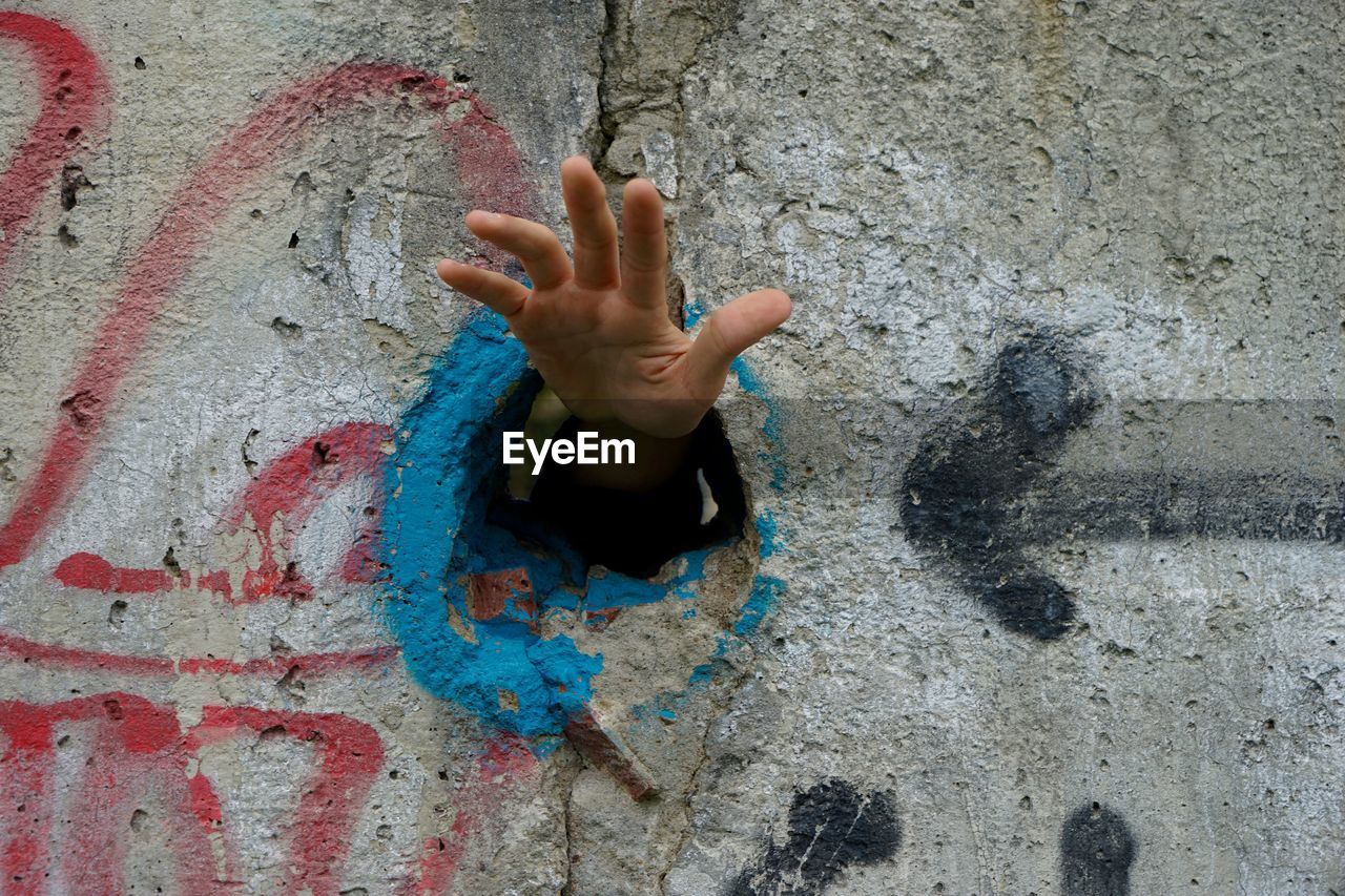 Hand in hole on concrete wall