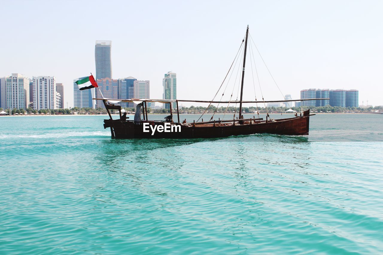 Boat in river against buildings