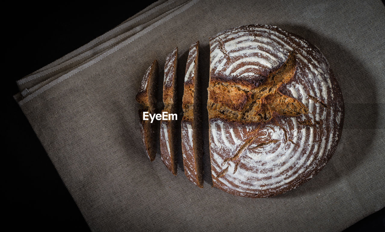 Directly above shot of bread on fabric on black background