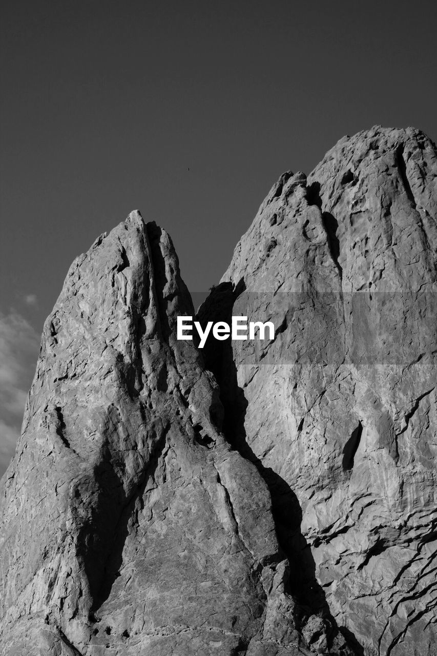 LOW ANGLE VIEW OF ROCK FORMATIONS AGAINST CLEAR SKY