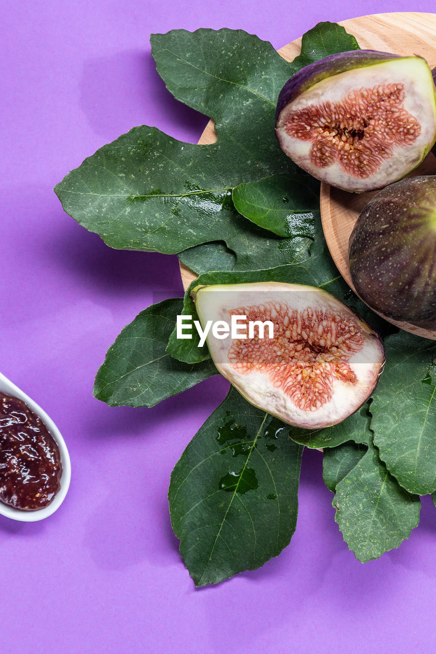 food and drink, food, healthy eating, wellbeing, freshness, plant, leaf, plant part, no people, common fig, indoors, produce, fruit, studio shot, high angle view, still life, purple, green, colored background, vegetable, plate, flower, slice