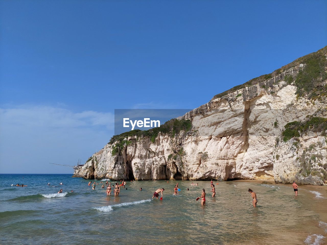 PEOPLE ENJOYING AT BEACH AGAINST SKY