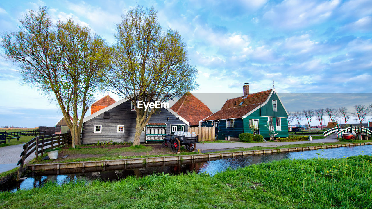 BUILDINGS BY RIVER AGAINST SKY