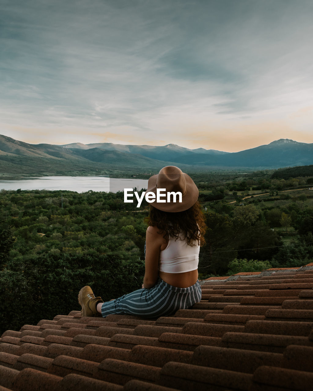 Woman on a roof looking at the sunset