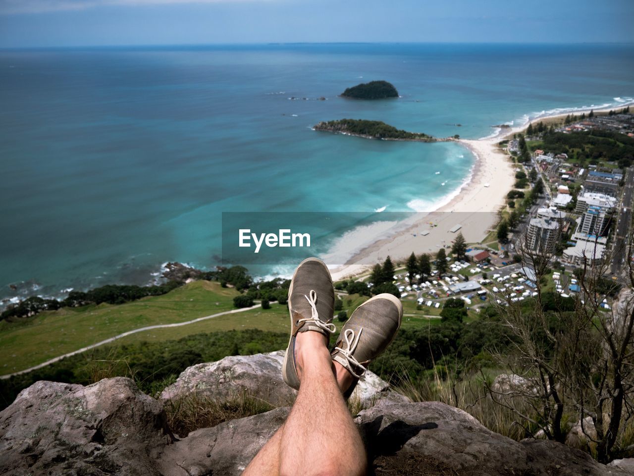 Low section of man on mountain by sea