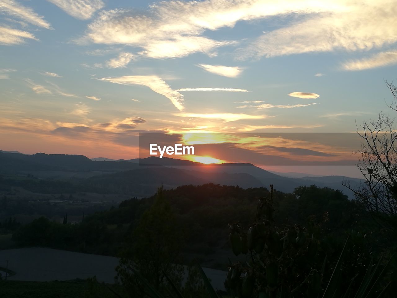 SCENIC VIEW OF SILHOUETTE MOUNTAINS AGAINST ORANGE SKY