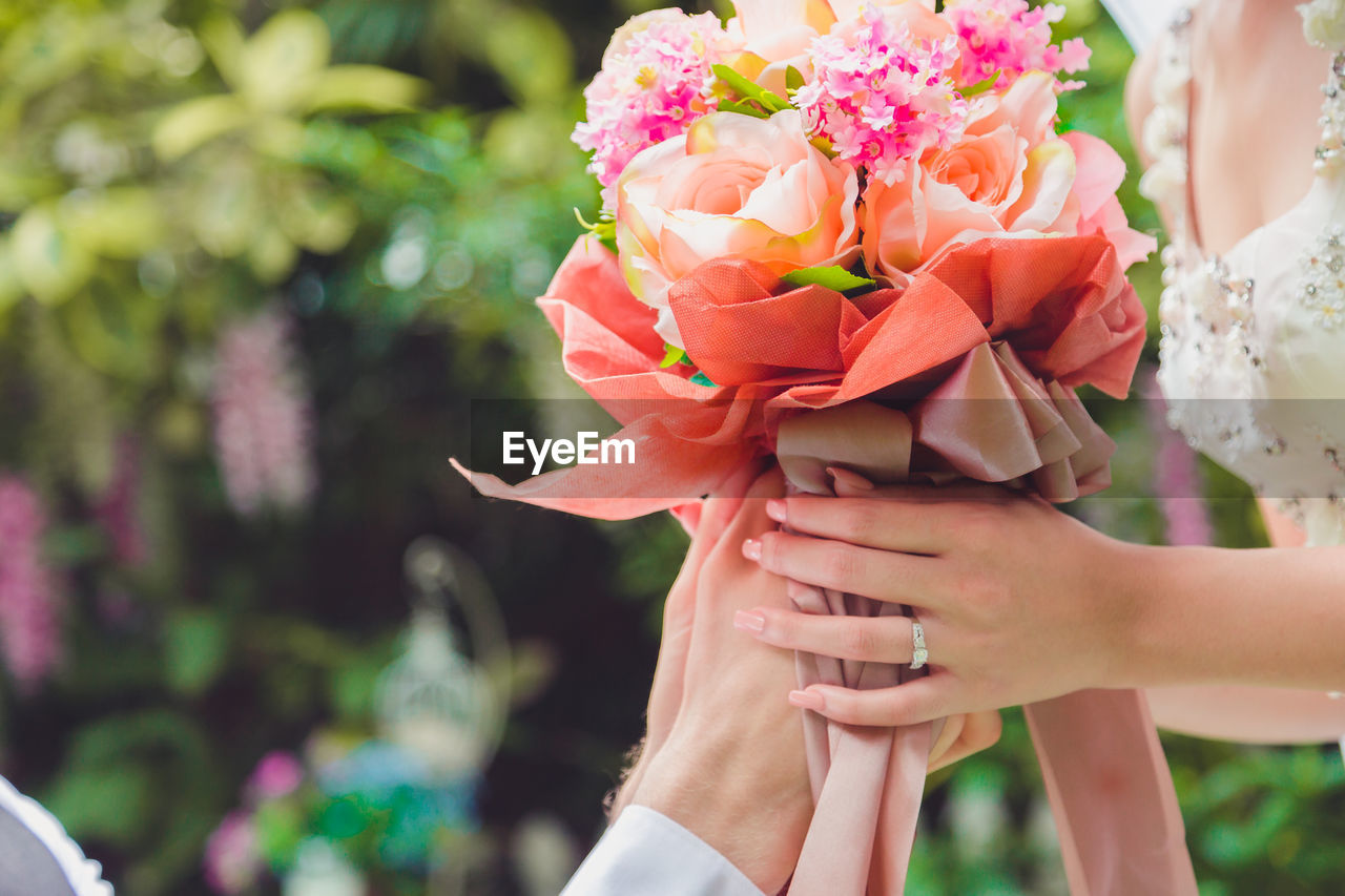 Bouquet in the hands of the groom. to make a happy wedding gift to a young bride.