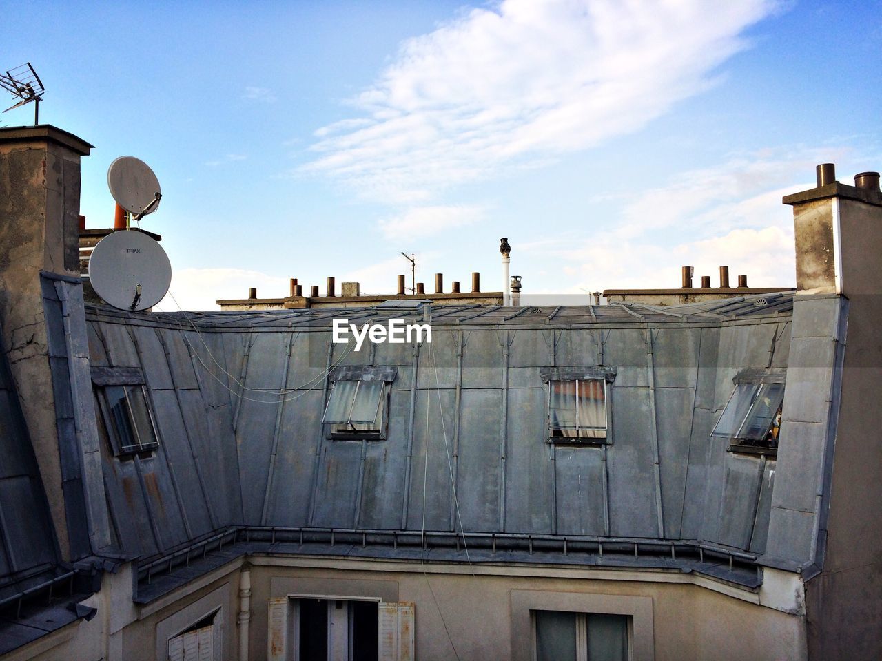 Satellite dish on building against sky