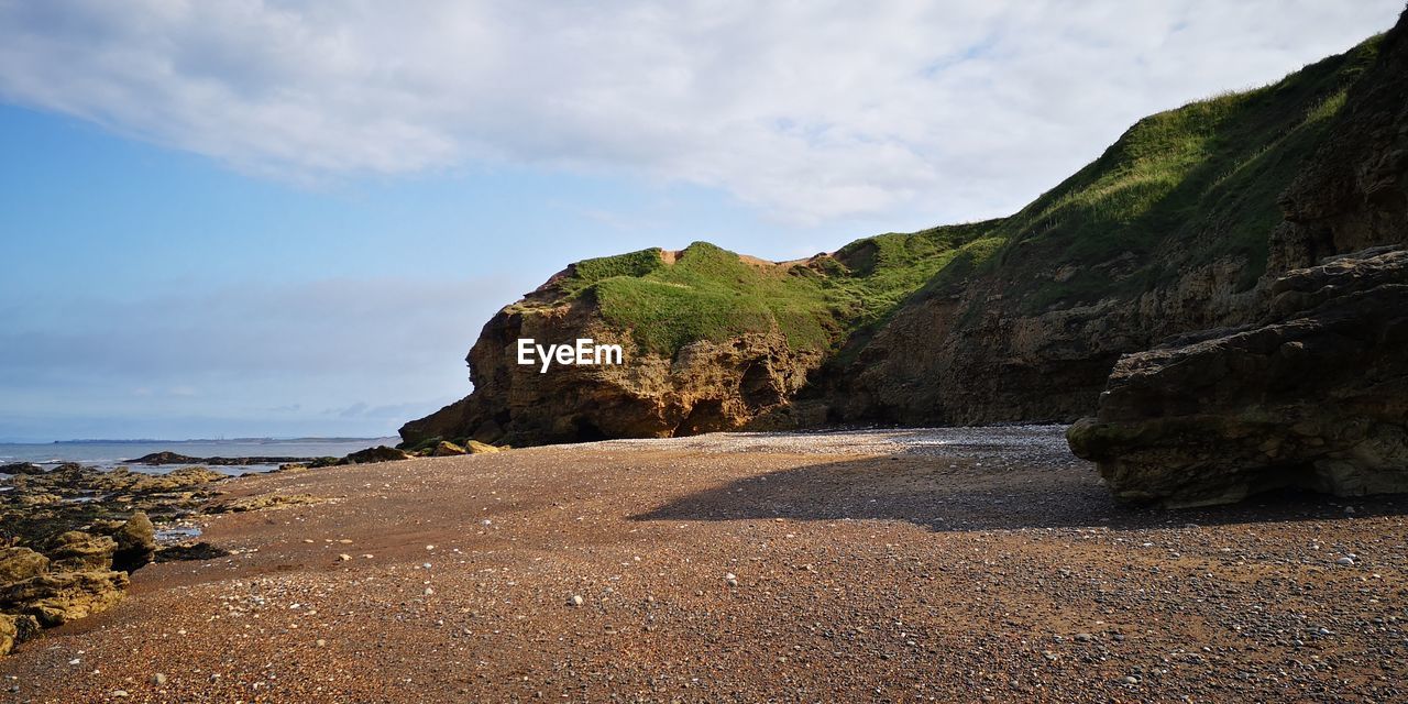 Scenic view of sea and mountains against sky