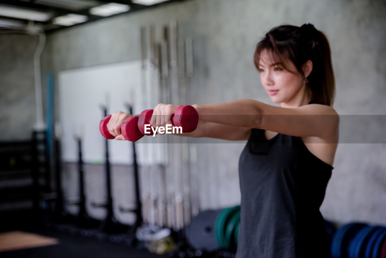 Woman lifting dumbbells in gym