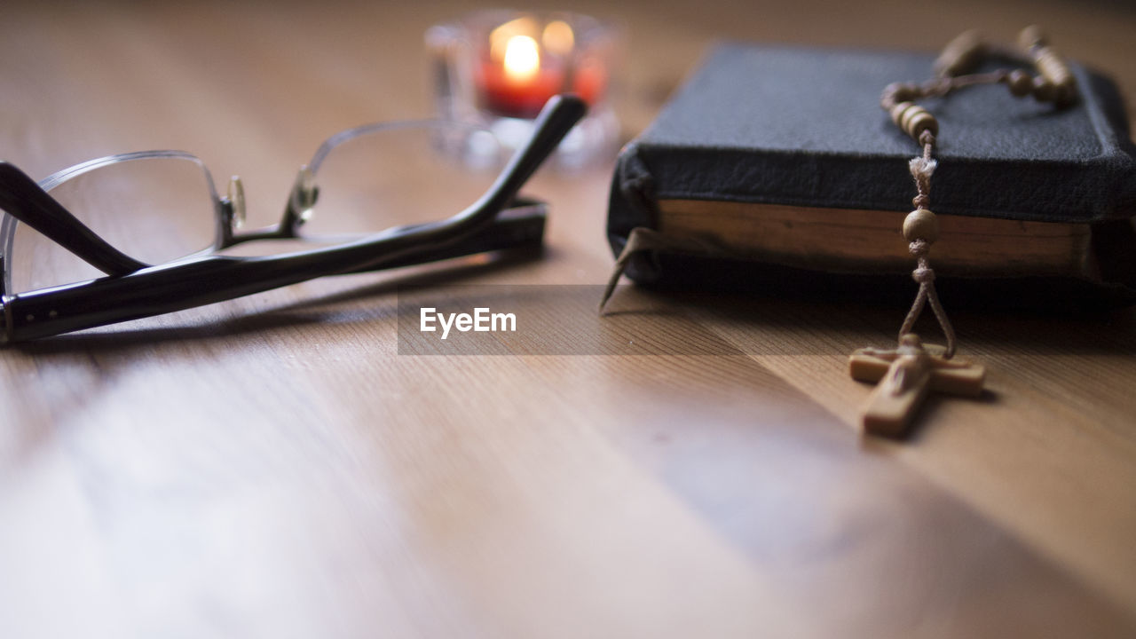 Close-up of eyeglasses and bible on table