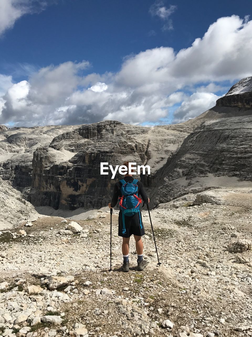 Full length of man standing on rock against sky