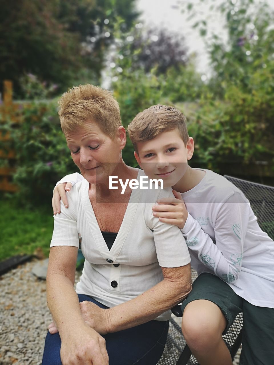 Portrait of boy sitting outdoors with his gran 