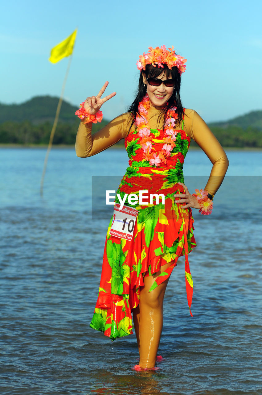 FULL LENGTH OF WOMAN STANDING BY SEA